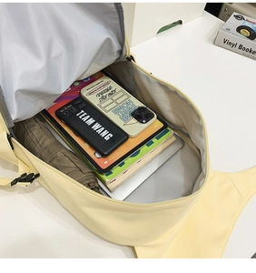 Spacious interior of the pale yellow canvas backpack showing laptop and books storage