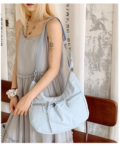 Detail der hellblauen Nylon-Sichel-Tasche mit verstellbarem Gurt, getragen von einem Model
