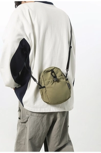 Gros plan sur le sac bandoulière imperméable vert olive avec sangle réglable et fermeture