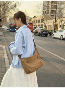 Close-up of brown waterproof nylon messenger bag featuring a CHUANGMI woven brand label