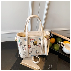 Detail of canvas bucket bag with colorful graffiti prints and gold-tone metal hardware