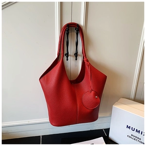 Close-up of red lychee pattern leather tote bag with a matching small round coin purse