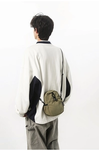 Sac bandoulière imperméable en nylon vert olive porté pour le trajet quotidien