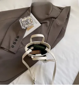 Vue de dessus du mini sac blanc montrant la capacité pour téléphone et portefeuille avec bandoulière