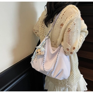 Detail of light purple leather hobo tote bag with silver chain strap and bear charm