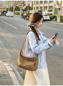 Macro detail of the brown water-resistant nylon messenger bag with adjustable strap