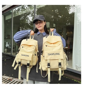 Detailed comparison of large and small yellow canvas backpacks with buckle closure