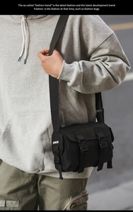 Macro view of black nylon messenger bag with buckle straps and adjustable shoulder strap