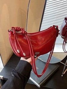 Sac à main demi-lune rouge brillant avec poignée nouée et détails de couture courbés