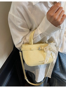 Hellgelbe Mini-Handtasche mit Faltenstruktur, Perlenanhänger und verstellbarem Schultergurt