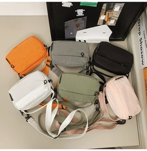 Flat lay view of six colorful nylon mini crossbody bags with adjustable straps in a modern set