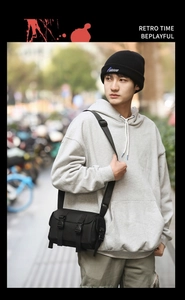 Detailed view of a black cylinder messenger bag made of durable nylon with buckle closures