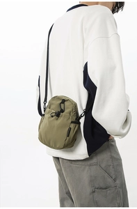 Vue macro de la sacoche en nylon imperméable vert olive avec poche à cordon et mousqueton