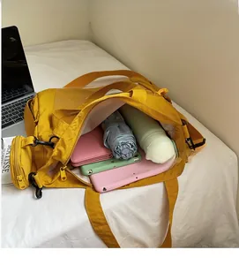 Detail view of large mustard nylon tote bag showing spacious interior with personal items