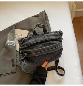 Detail of washed grey denim bag on a stylish background with a gray blazer