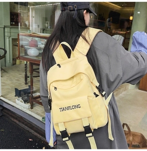 Detail of yellow canvas backpack with TIANFLONG embroidery on waterproof nylon
