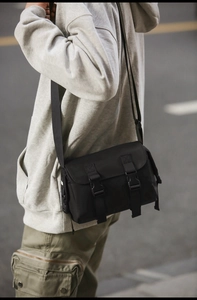 Detail of black nylon messenger bag with adjustable strap and buckle closure for men