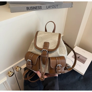 Detail of vintage canvas and leather backpack with front pockets and silver buckles