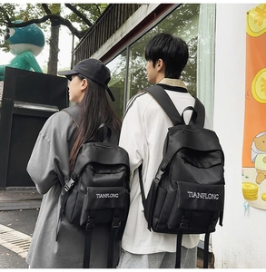 Size comparison of large and small black canvas backpacks with buckle straps and logo
