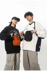 Détail de sacs à bandoulière en nylon étanche orange et noir avec poches à cordon