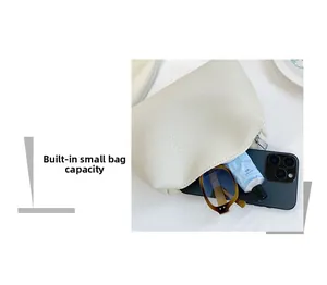 Internal storage capacity of a beige pebbled leather tote bag with phone and sunglasses