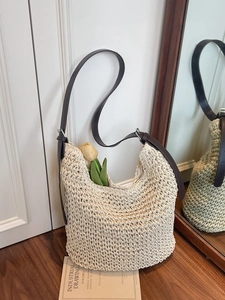 Handwoven cream tote bag with brown leather strap and intricate hollow texture for summer