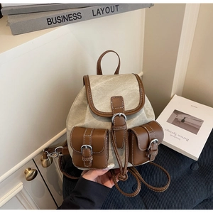 Detailed macro view of vintage canvas and leather backpack stitching with metal buckle accents