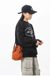 Détail du sac bandoulière orange étanche en nylon avec cordon de serrage et sangle
