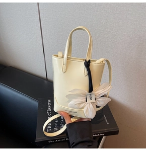 Détail du sac seau en cuir blanc crème avec fleur décorative en soie et sangle