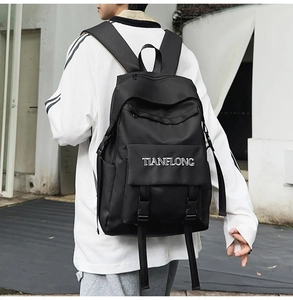 Detailed outdoor side view of a black tactical backpack with adjustable buckles and logo