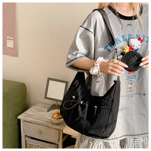 Detail der schwarzen Hobo-Tasche mit Kordelzugtasche und abnehmbarer Mini-Geldbörse