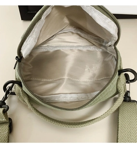 Top view of a light green nylon crossbody bag showing the inner lining and zipper closure