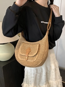 Handwoven straw shoulder bag with leather trim and saddle shape for summer vacation