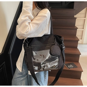Detail of black nylon tote bag with transparent PVC pocket and round coin purse attachment