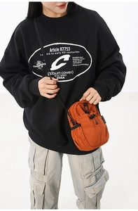 Détail du sac bandoulière orange en nylon imperméable avec cordon de serrage et sangle