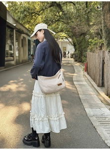 Detail view of adjustable strap on off-white water-resistant nylon hobo bag for women