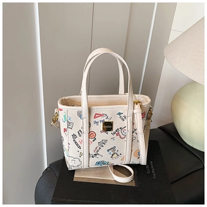 Close-up of a white graffiti bucket bag with colorful prints and gold hardware detail