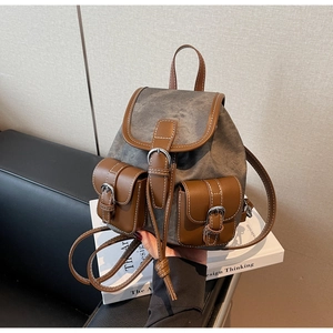 Detail of vintage canvas backpack with brown leather trim and silver metal buckles