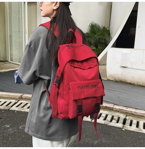Detail view of the durable red canvas backpack with adjustable side buckle straps