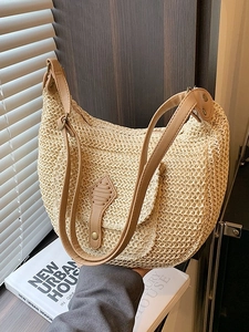 Casual half-moon straw shoulder bag with brown leather strap and metal stud details