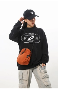 Détail du sac à bandoulière étanche orange vif avec cordon de serrage noir sur un mannequin