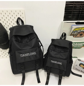 Detail view of two sizes of black minimalist canvas backpacks with TIANFLONG logo