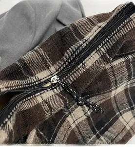 Dettaglio ravvicinato della cerniera nera e della trama del tessuto a quadri vintage