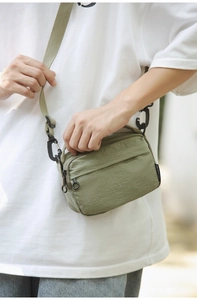 Detailed close-up of olive green nylon crossbody bag with ripstop texture and buckle