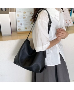 Detail of adjustable silver buckle and black lychee texture leather strap on shoulder bag