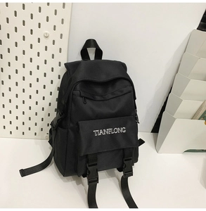 Detail of black canvas backpack with TIANFLONG embroidery and plastic buckle closure