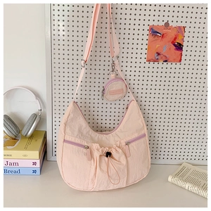 Detailansicht der rosa Halbmond-Tasche mit Mini-Geldbeutel und violetten Zippern