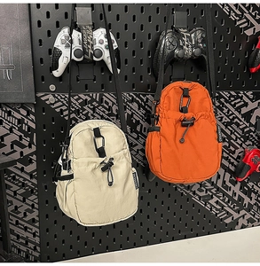 Détail des sacs à bandoulière en nylon imperméable beige et orange avec mousqueton