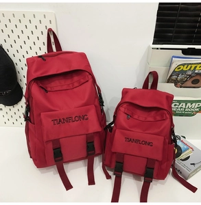 Close-up of dark red canvas backpack set with flap design and black buckle straps