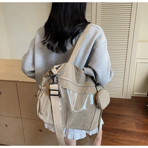 Detail of khaki nylon tote bag with front zipper pocket and side elastic pouches
